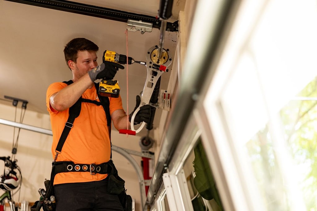 Cunningham team using a drill to installi a garage door