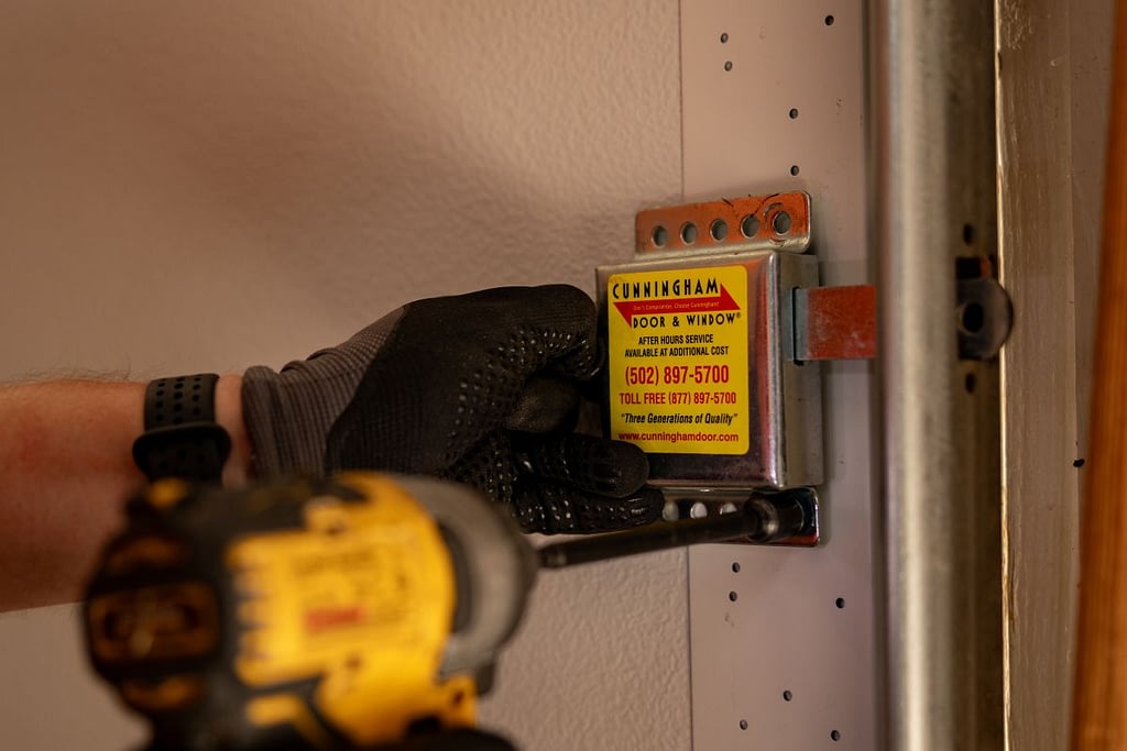 Close-up of Cunningham team using a drill to install a garage door