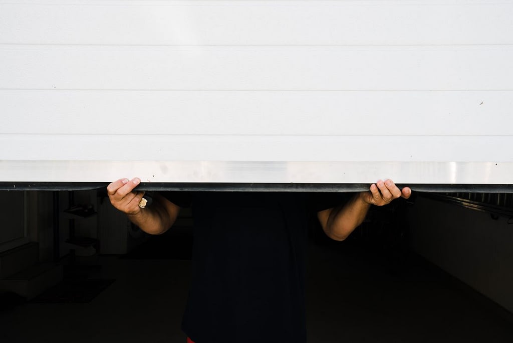 garage door bottom seal replacement man holding garage door