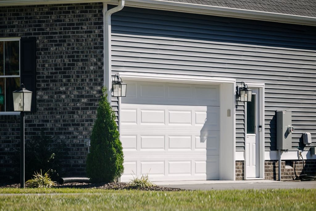 White garage door on a house with grey siding