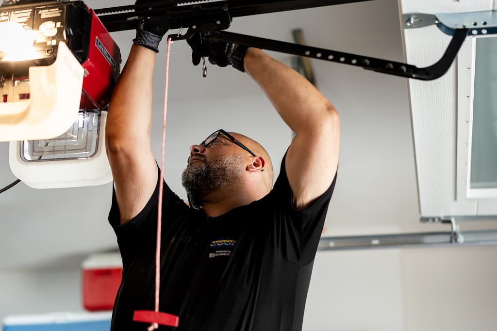 Cheney Door team fixing a garage door spring