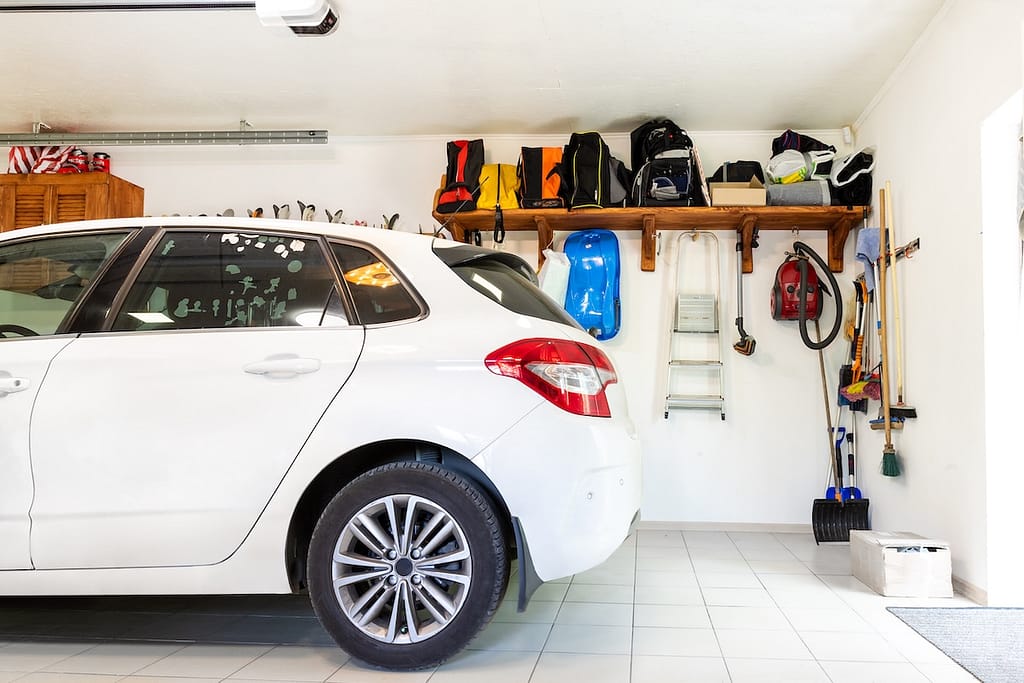 Home suburban car garage interior with wooden shelf