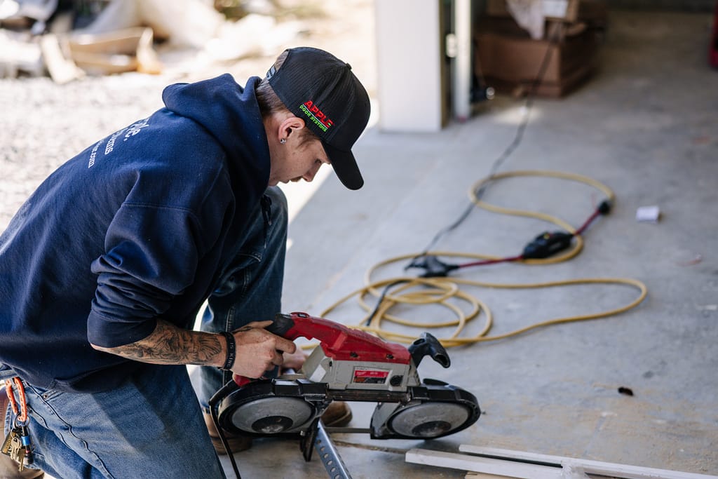 commercial garage doors guy using cutter to remove a piece of door
