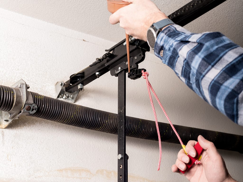 diy garage door repair Metal can of oil is used to lubricate a release leaver for a garage door