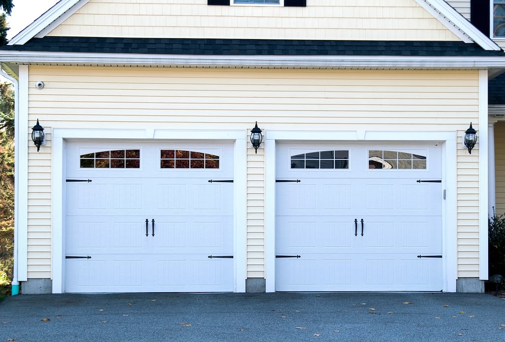 YELLOW HOUSE WITH WHITE GARAGE DOORS