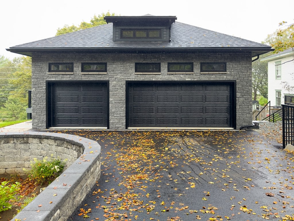 A double and single-width black metal garage door